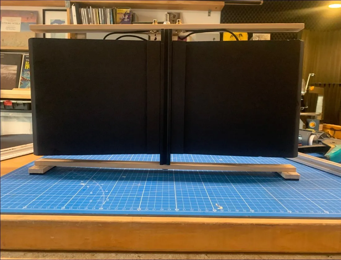 Deux panneaux vibrants noirs en cours d'assemblage sur tapis de découpe bleu