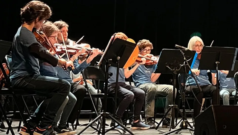 L'Orchestre des Colibris en concert — jeunes musiciens en t-shirts bleus avec violons et alto sur scène
