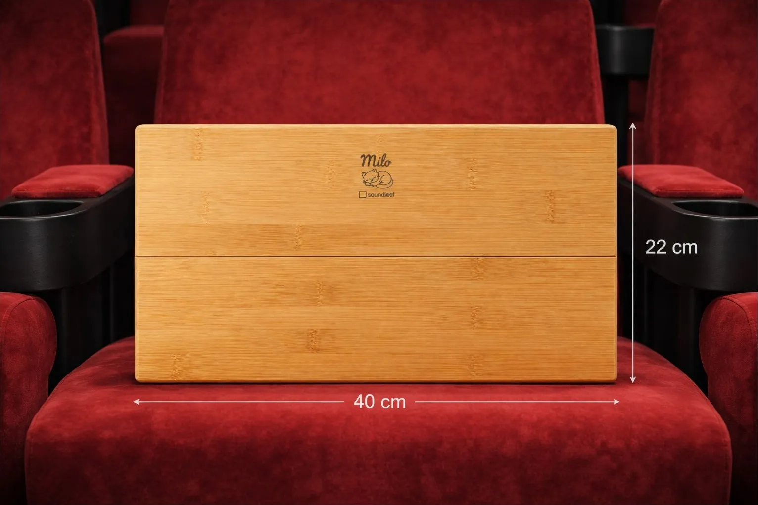 Milo placé sur un fauteuil de théâtre rouge — dimensions 40 × 22 cm